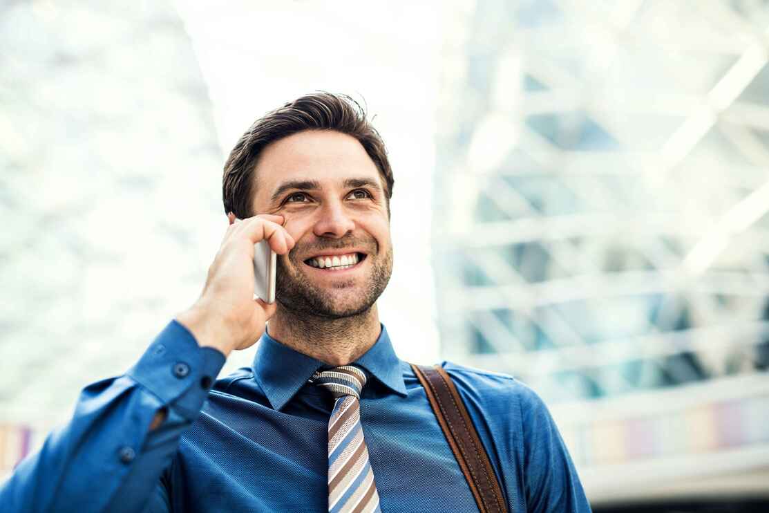 Homme d'affaires en chemise bleue utilisant son smartphone professionnel