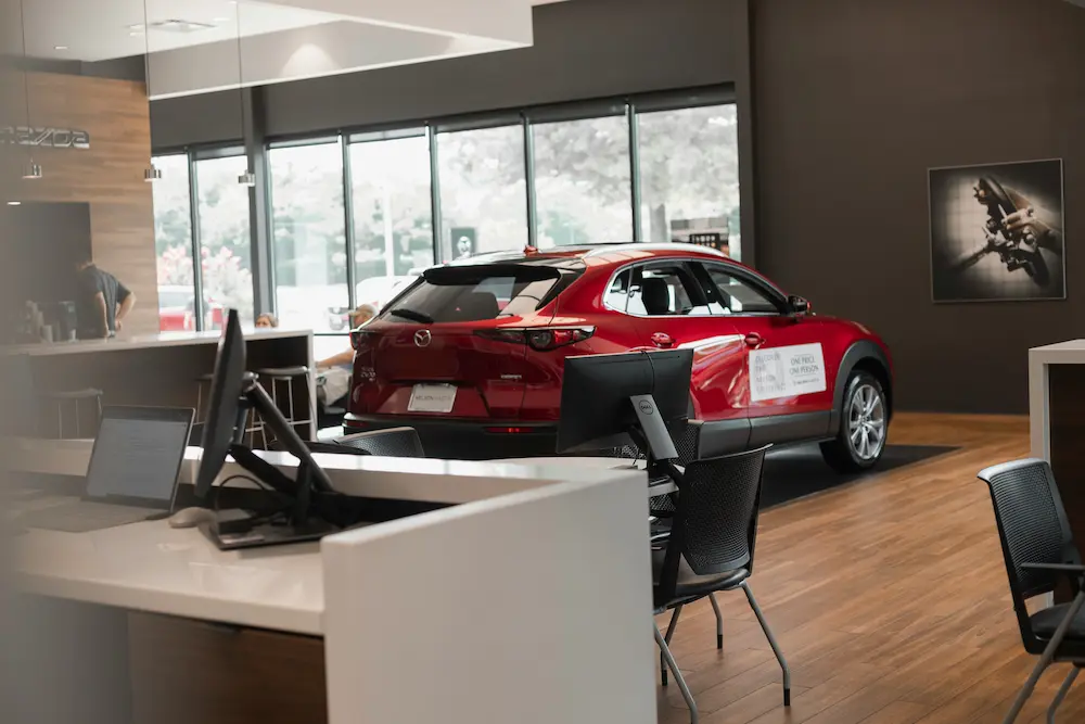 Concession automobile moderne avec véhicule rouge en showroom