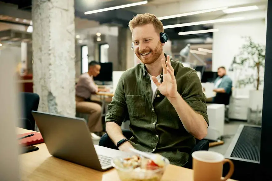 Homme souriant avec casque audio dans un bureau moderne - Communication professionnelle Saylo