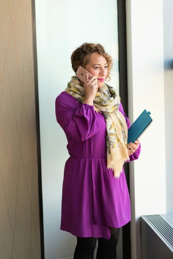 Femme professionnelle utilisant smartphone et tablette dans un environnement de bureau moderne