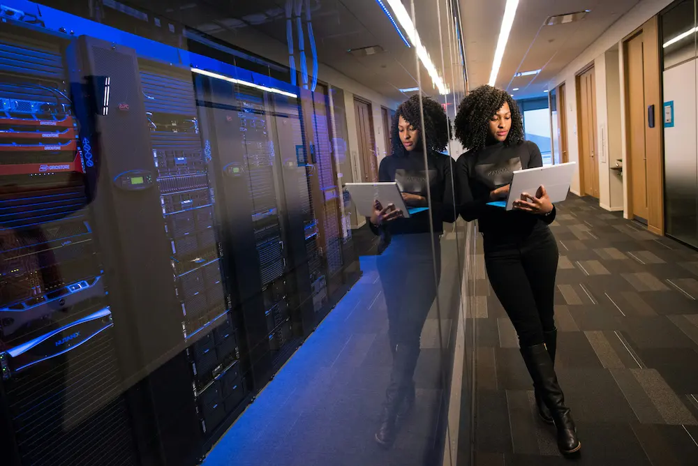 Professionnelle travaillant dans un centre de données moderne avec serveurs et infrastructure de stockage