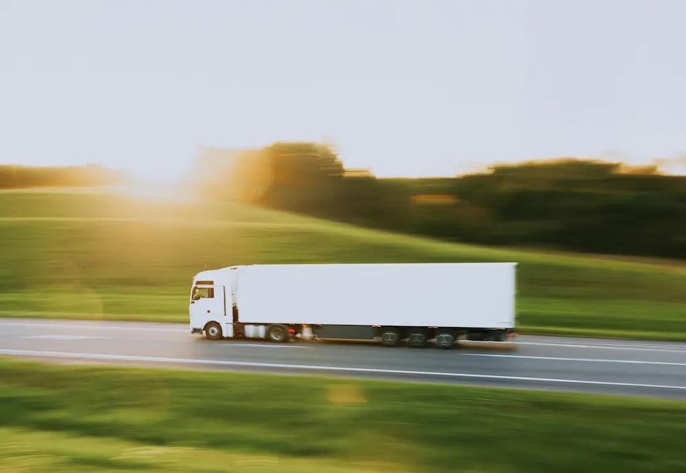 Camion semi-remorque blanc en mouvement sur l'autoroute