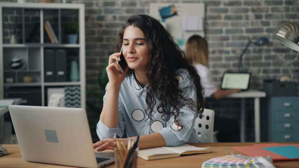 Professionnelle utilisant un smartphone dans son espace de travail moderne